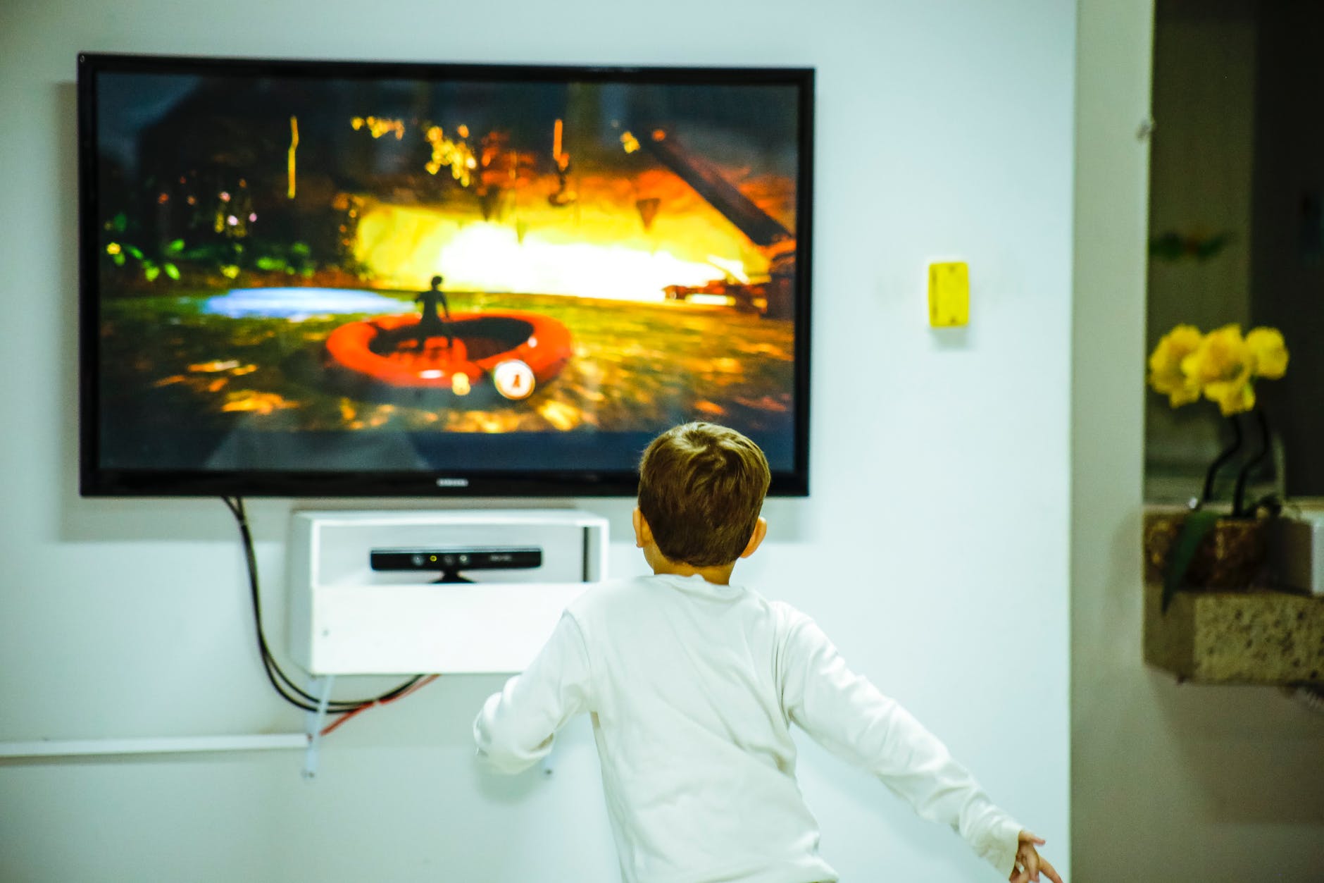 boy standing in front of flat screen tv